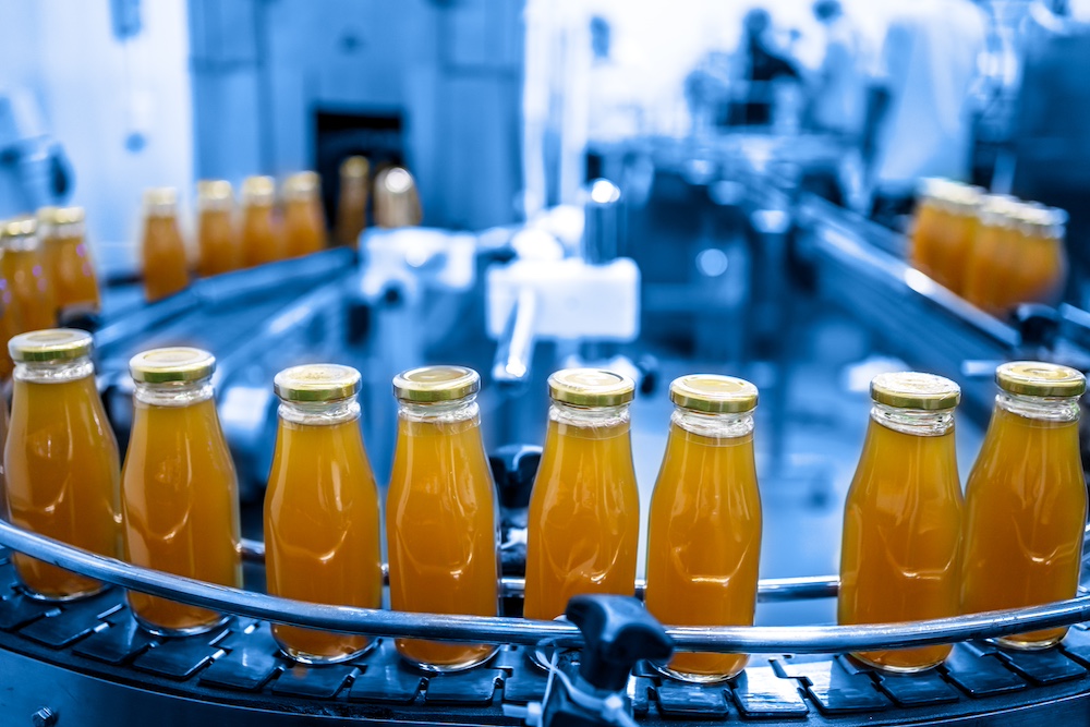 Unlabeled beverages go by at a factory